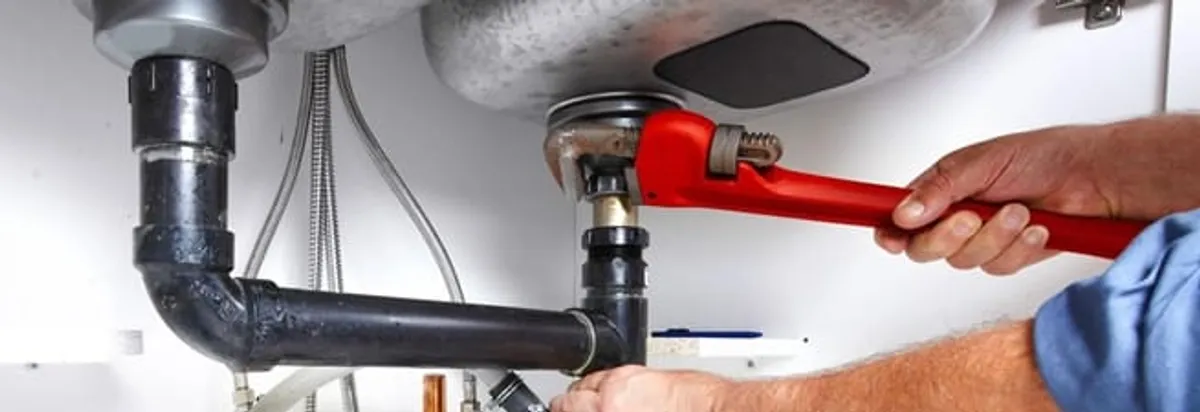 Garbage disposal repair technician tightening the sink drain and disposal connection in Allentown, PA