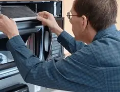 Appliance repair technician replacing a microwave vent filter in Allentown, PA