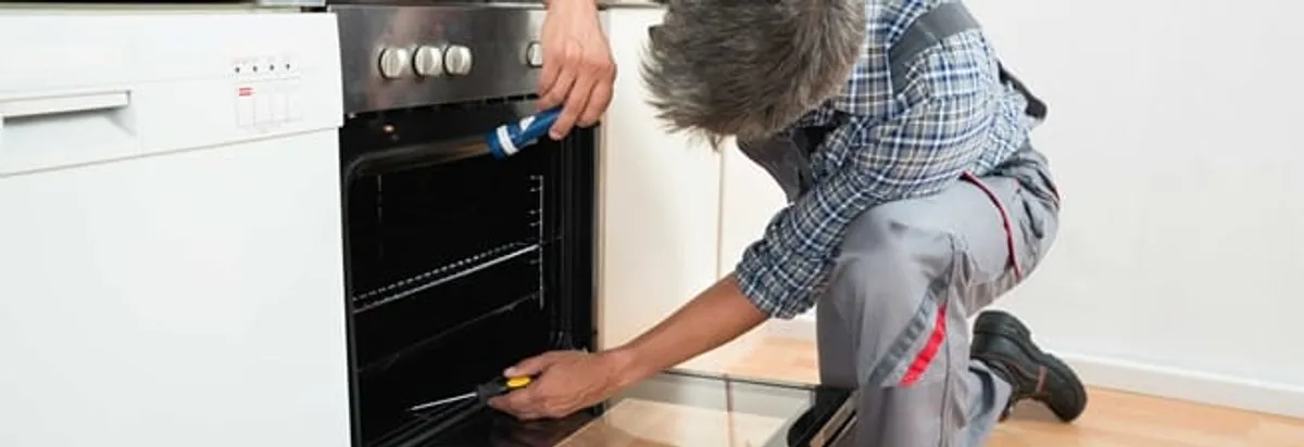 Oven repair technician inspecting and servicing an electric oven in Allentown, PA