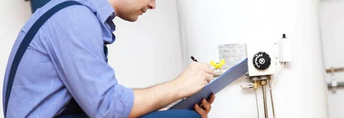 Water heater repair technician inspecting the unit and recording service notes in Allentown, PA